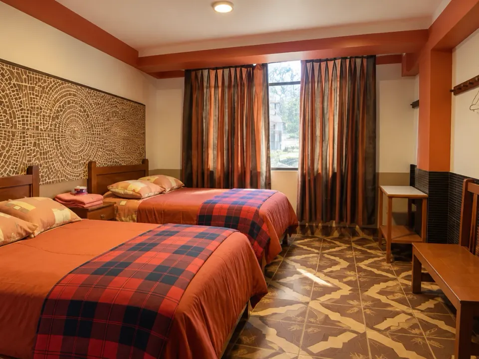 Two beds, a window, and a TV in the premium double room at Hotel Manantial, Churín