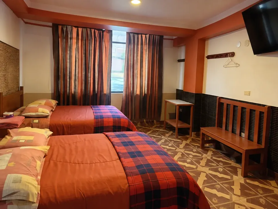 Two beds and a seating area in the premium double room at Hotel Manantial, Churín