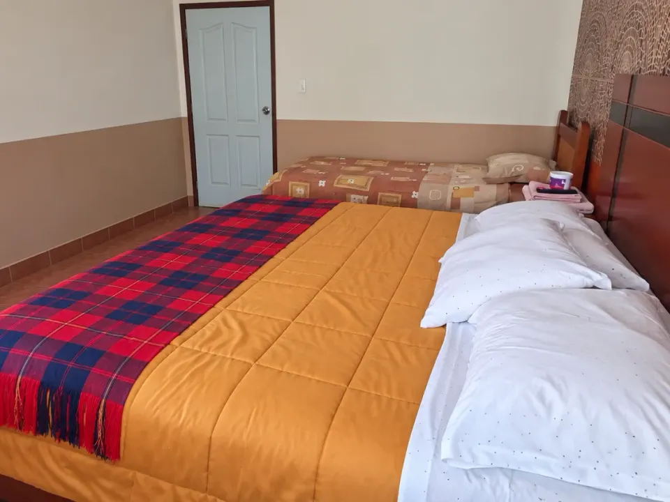 Side view of the king bed and single bed in the family suite at Hotel Manantial, Churín