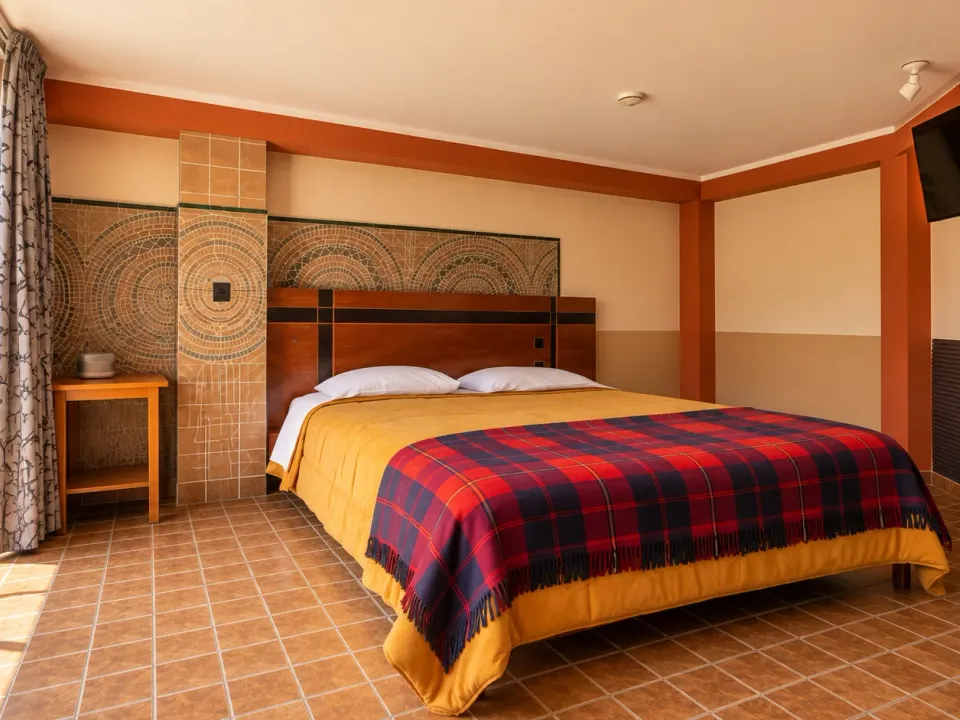 Front view of the king room with a smart TV and balcony at Hotel Manantial, Churín